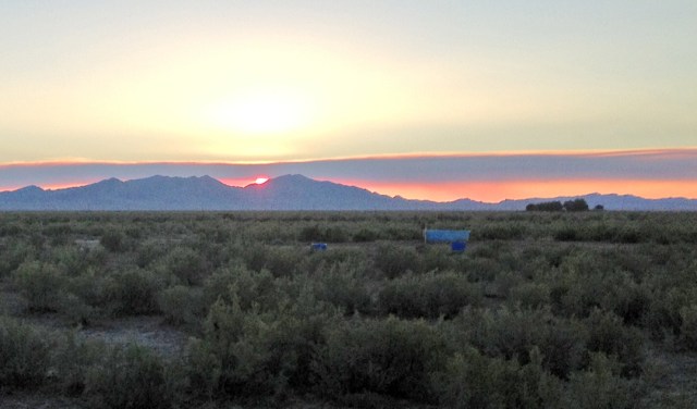 Sunset over Lady Laird Peak in the Big Drum Mountains. The plume of smoke through which the sun is setting was coming from a wildfire beyond Swasey Peak.