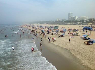 Santa Monica beach as seen from the pier. The usual summer haze fades away the Malibu Hills.